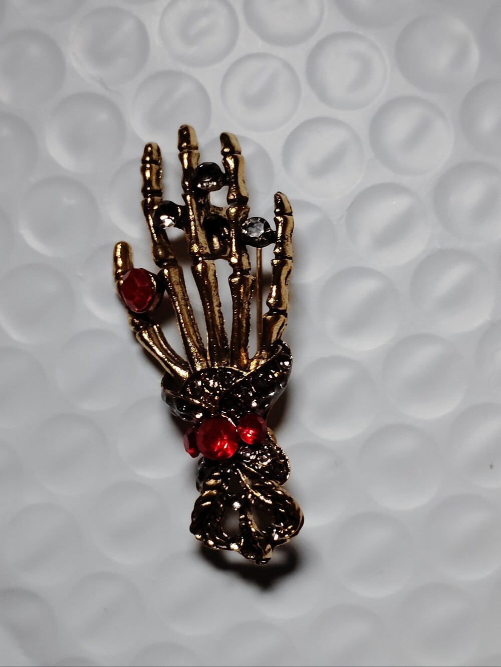 Gold-Tone Skeleton Hand Brooch with Red and Black Stones